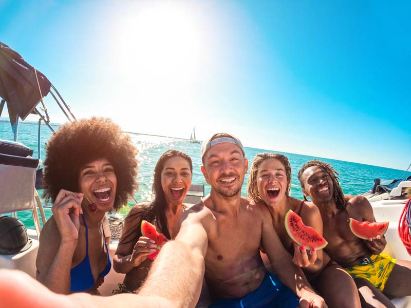 Happy,Multiracial,Friends,Eating,Watermelon,While,Doing,Sea,Tour,With